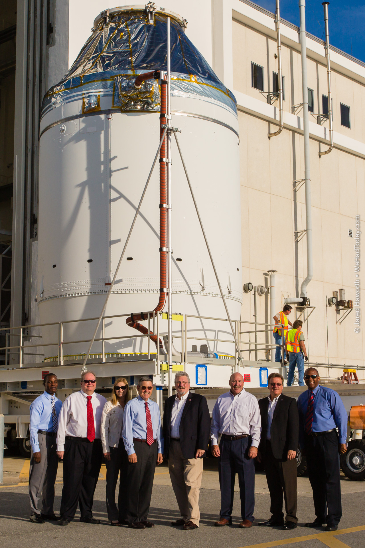 NASA and Lockheed Martin employees pose in front of the recently-completed Orion EFT-1 crew spacecraft.