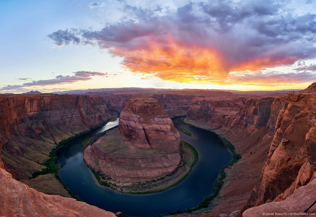 The setting sun illuminates the clouds while the crescent moon hangs over Horseshoe Bend