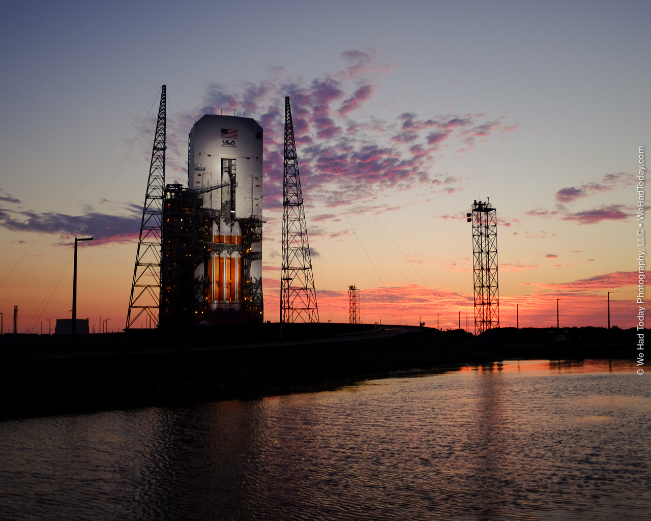 United Launch Alliance's Delta IV Heavy rocket, lit by xenon spotlights as the sun rises behind SLC-37B.